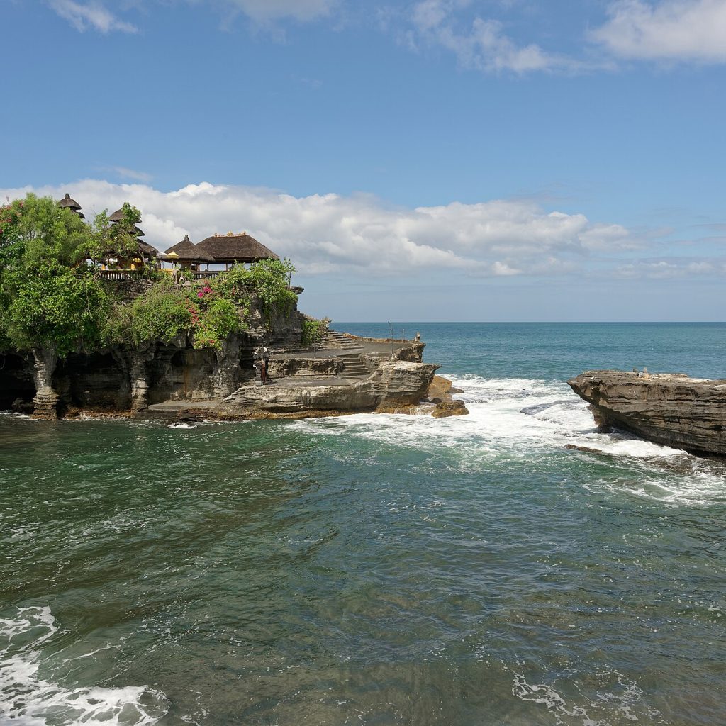 Bali Turu programındaki Tanah Lot Tapınağı'nın dalgalarla çevrili kayalık kıyı şeridinden görünümü