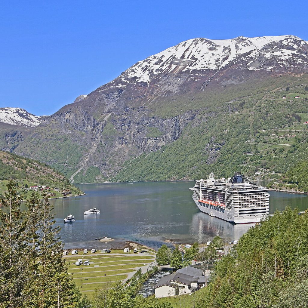 Norveç'teki Geiranger Fiyordu'nun dik dağ yamaçları arasında uzanan turkuaz su yüzeyinin görünümü